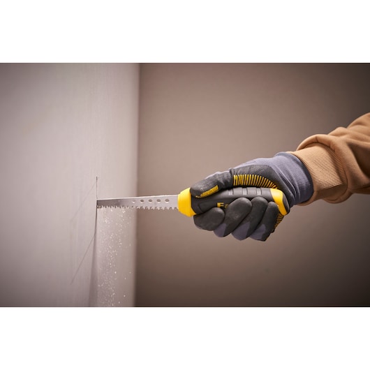 STANLEY 0-20-556 drywall saw with yellow and black handle, cutting wall, side view.