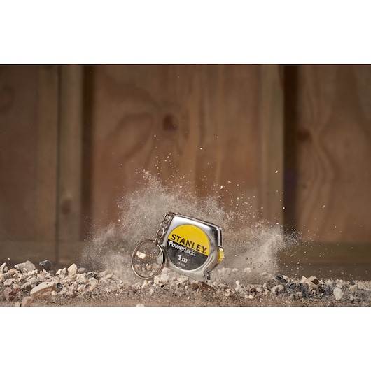 STANLEY 0-39-055 PowerLock keychain tape measure on dusty ground, product photography.