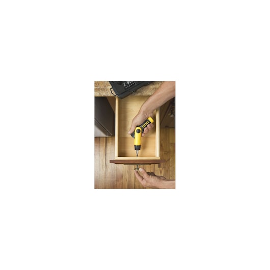 STANLEY 0-63-022 screwdriver being used to install a drawer handle, photography from above on wooden floor.