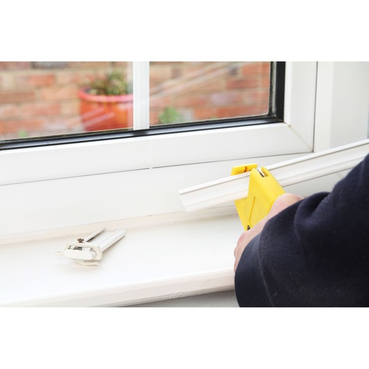 STANLEY 0-70-450 mitre box set on a window sill with white trim being cut, close-up photography.