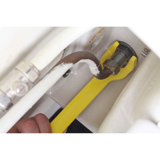 STANLEY 0-70-454 yellow pipe wrench tightening a pipe fitting, close-up photo.