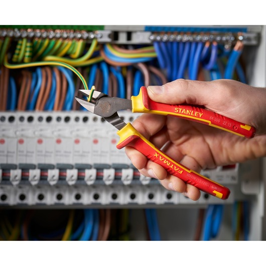 STANLEY 0-84-009 insulated diagonal cutting pliers held by hand, cutting wire in electrical panel.