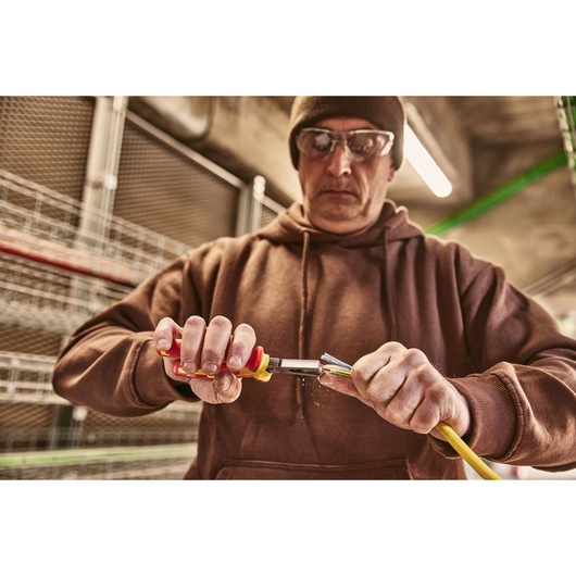 Photo of STANLEY 0-84-010 pliers being used to strip insulation from a yellow electrical cable.