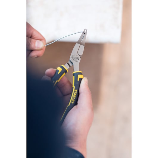 STANLEY 0-84-495 pliers with yellow and black handles in use bending wire, close-up photography.