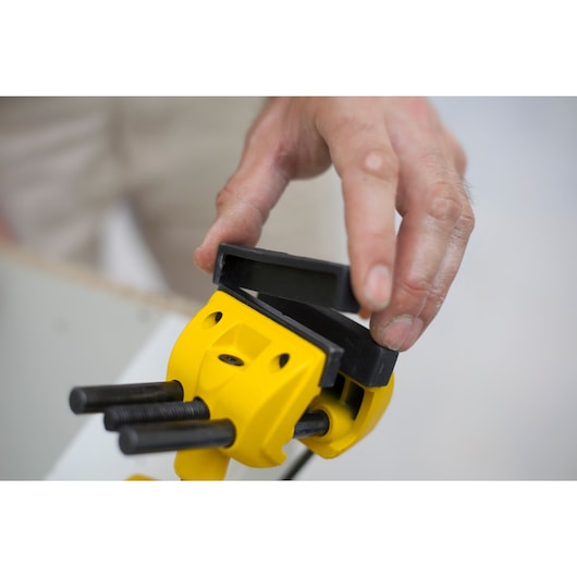 STANLEY 1-83-069 photography of yellow clamp with black jaws being adjusted by hand.