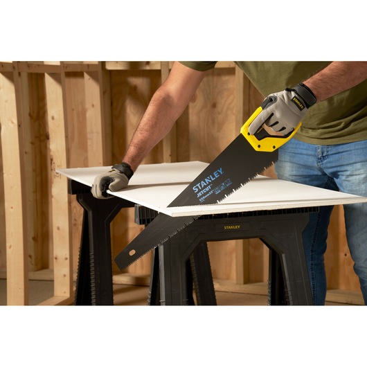 STANLEY 2-20-149 hand saw cutting board on workbench, close-up, yellow and black handle, photography.