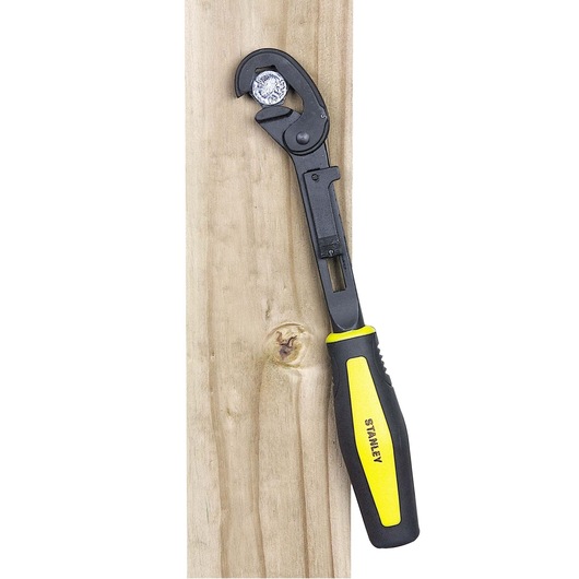 STANLEY 4-87-988 adjustable wrench with black and yellow handle gripping a bolt on wood, side view.