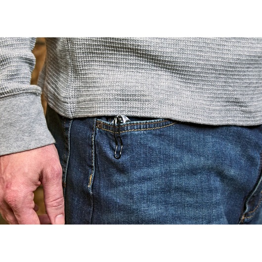 A close-up image of a person wearing blue jeans and a grey textured shirt. The person has a STANLEY utility knife clipped to the front pocket of their jeans.