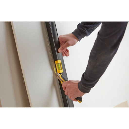 Photo of STANLEY FMHT42562-1 level tool being used to cut drywall panel.