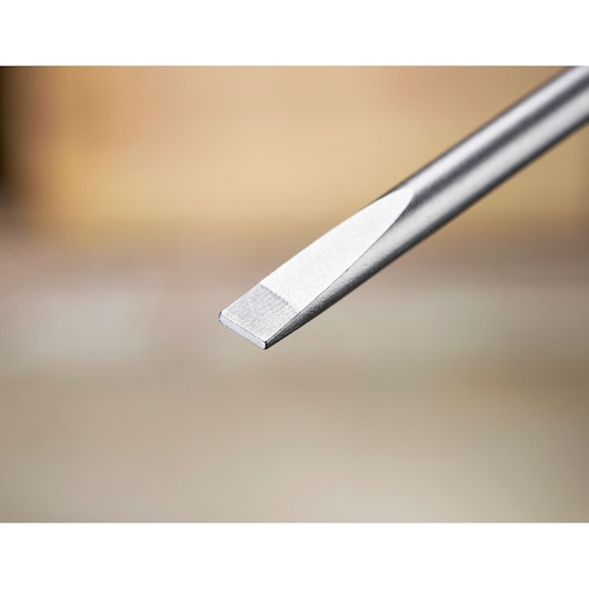 Close-up of a flathead screwdriver tip, metallic, against a blurred background.