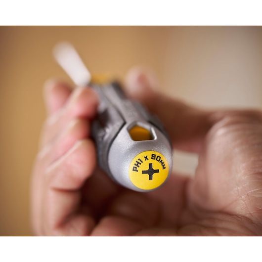 Close-up of a hand holding a Stanley screwdriver with a yellow PH1 x 80mm tip.