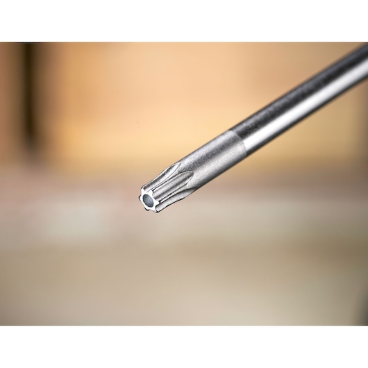 Close-up of a metal precision screwdriver bit with a star tip, shown against a blurred background.