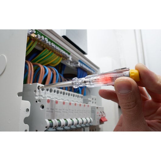 STANLEY FMHT66426-0 voltage tester screwdriver in use on electrical panel, close-up view.