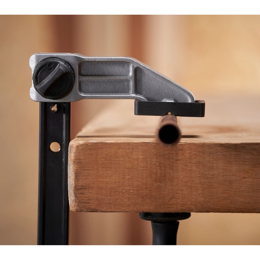 STANLEY FMHT83006-0 clamp holding a metal pipe on a wooden workbench, side angle photography.