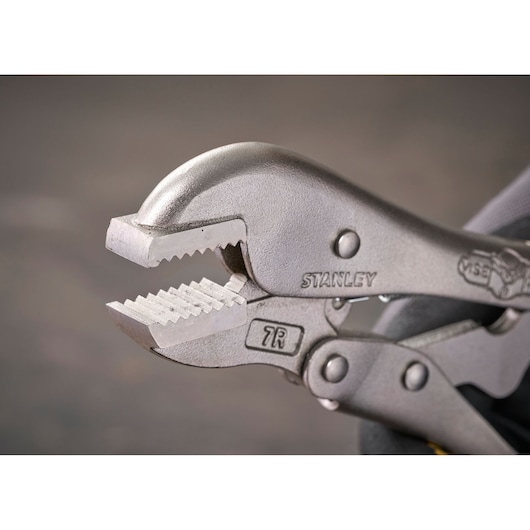 Close-up of a STANLEY locking plier with serrated jaws, designed for gripping and clamping objects securely.