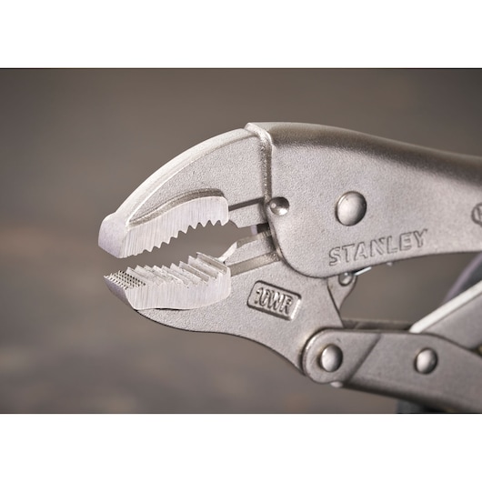 Close-up of STANLEY locking pliers with serrated jaws, metal finish, suitable for gripping objects tightly.