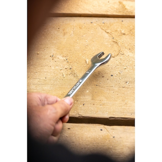 Stanley FMMT13071-0 wrench held by hand on a wooden surface, close-up photography.