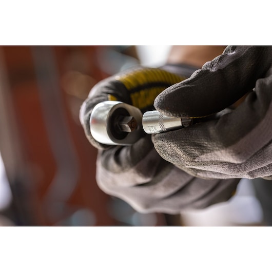 STANLEY FMMT17192-0 socket wrench held in gloved hands, close-up view, hand tool in use.
