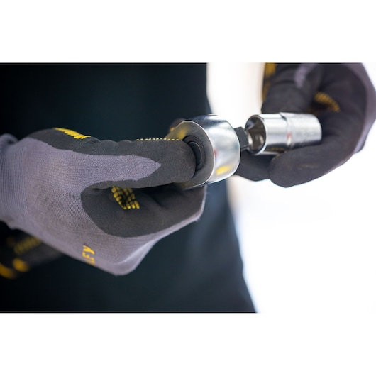 Photo of STANLEY FMMT17217-0 socket wrench in hand, close-up showing gloves and tool connection.