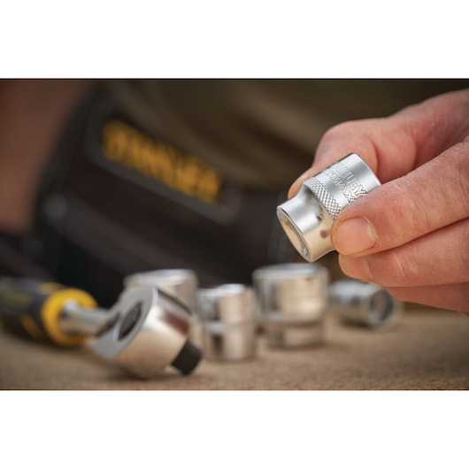 Photo of STANLEY FMMT17221-0 socket set with ratchet, close-up of hand holding metal socket.