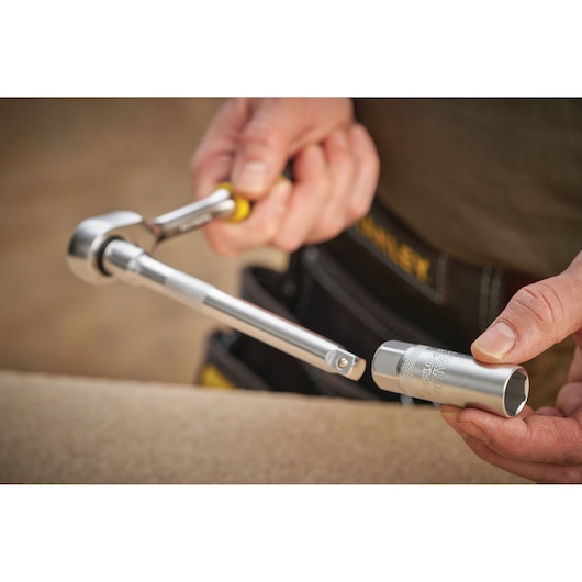 STANLEY FMMT17225-0 socket wrench held by hand with silver socket, close-up photo.