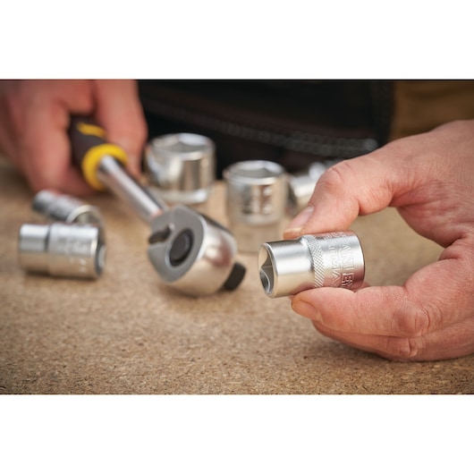 STANLEY FMMT17234-0 socket and ratchet tool set, close-up photo showing hand holding a chrome socket.