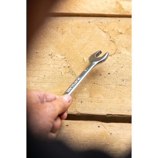 Photo of STANLEY FMMT82901-0 open-end wrench held by hand on a wooden workbench.