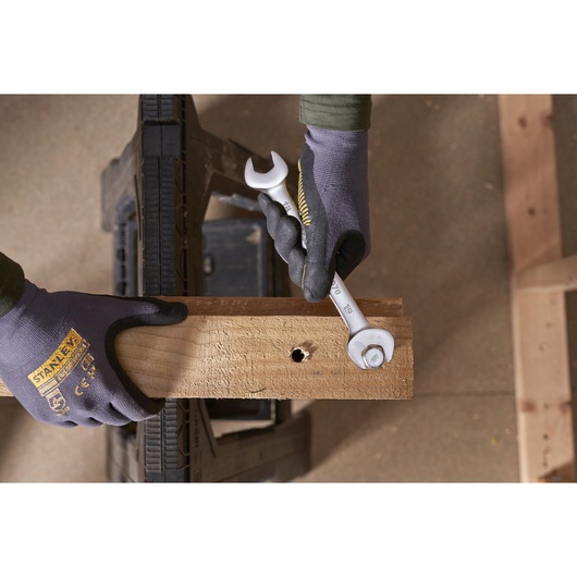 STANLEY FMMT82902-0 wrench in use tightening a bolt on a wooden plank, close-up from above.