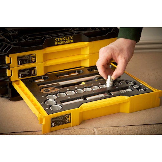 STANLEY FMMT98107-1 yellow tool set drawer with sockets and wrench, hand selecting socket.