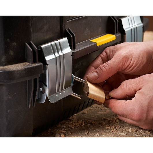 STANLEY FMST1-71219 toolbox front angle with metal latches and padlock, hands locking the latch