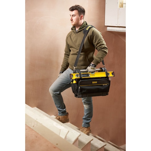 STANLEY FMST17626-1 tool bag with tools, carried by person on stairs, front angle photography.