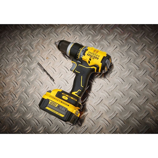 STANLEY SFMCD721M2K cordless drill with V20 battery on diamond plate surface, product photography.