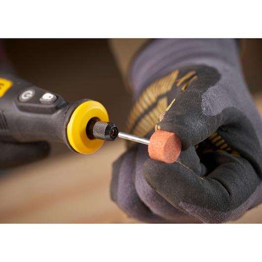 STANLEY SFMCE030B rotary tool close-up with sanding accessory held by gloved hand, product detail photography.
