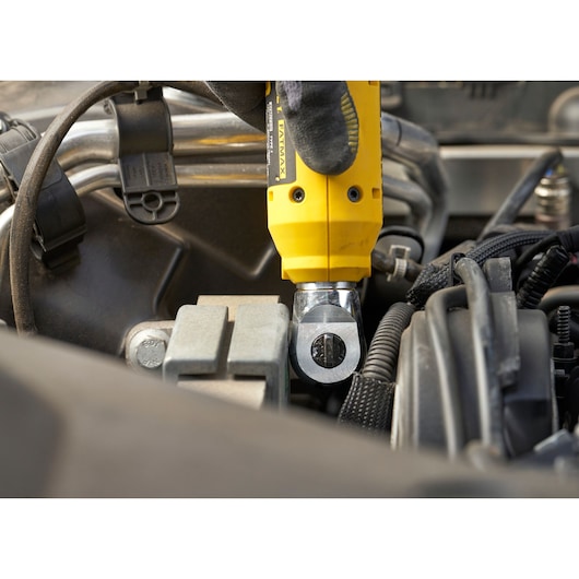 STANLEY SFMCF930B impact wrench used on an engine component, close-up photography.