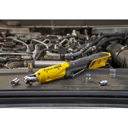 STANLEY SFMCF930B cordless ratchet tool with sockets shown on car engine photography.
