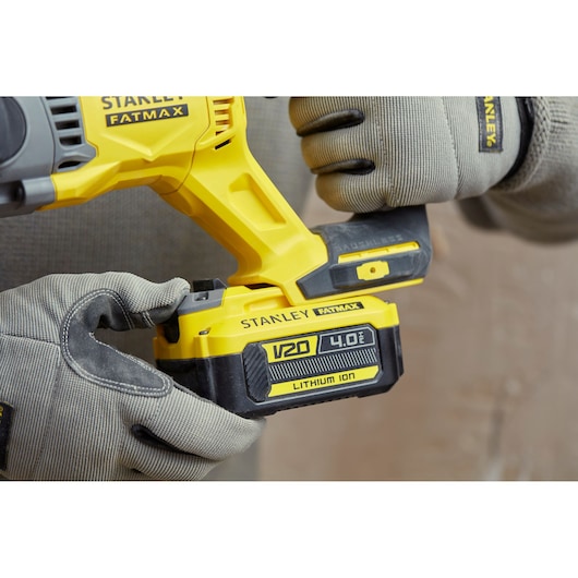 Photo of STANLEY SFMCH900M22 V20 Fatmax cordless tool with 4.0Ah lithium-ion battery held by gloved hands.
