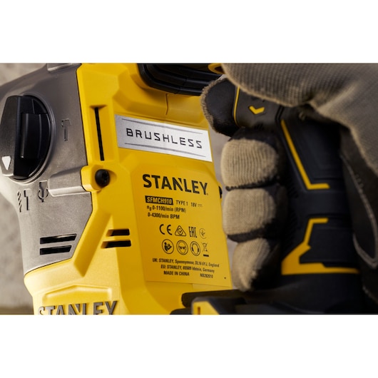 STANLEY SFMCH910M1T brushless rotary hammer close-up showing yellow housing and glove.