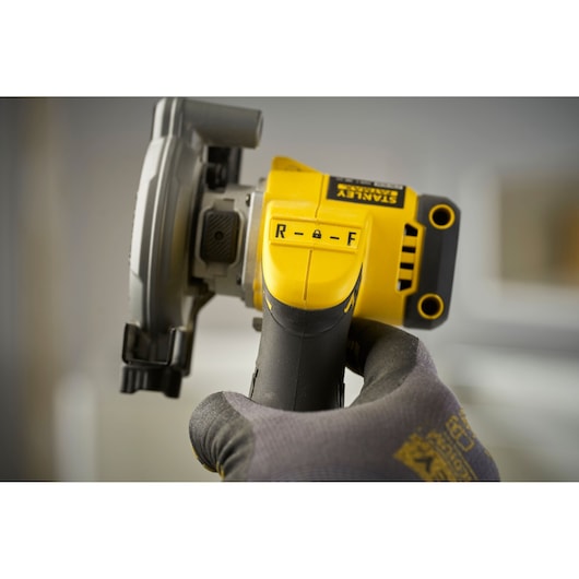 Photo of STANLEY SFMCM300B cordless saw handle showing directional switch and yellow-black design.