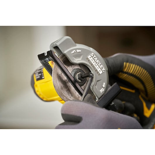 Photo of STANLEY SFMCM300B circular saw blade installation close-up with gloved hand and tool.