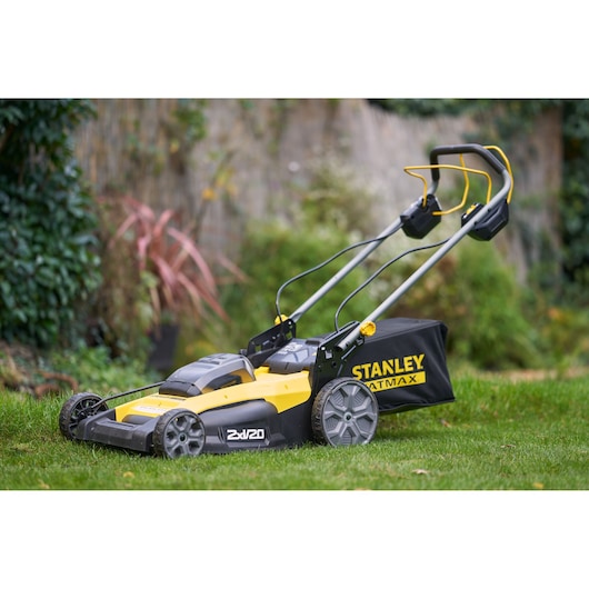 STANLEY SFMCMWS251B lawn mower, yellow and black, side view, on grass outdoors.