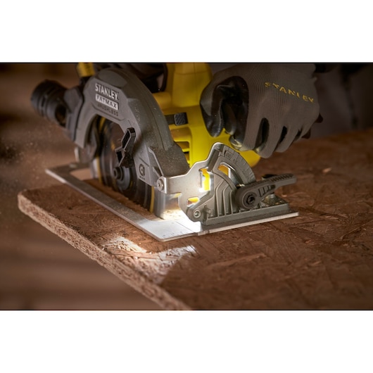 STANLEY SFMCS550B circular saw cutting wood, close-up view with gloved hand operating tool.