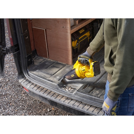 STANLEY SFMCVH001B handheld vacuum cleaner in use cleaning vehicle interior, shown from side angle.