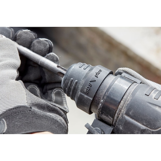 STANLEY SFMEH210K-QS rotary hammer close-up with SDS Plus drill bit being inserted, photography.