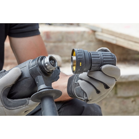 STANLEY SFMEH210K-QS rotary hammer showing accessory attachment held by gloved hands, outdoor close-up.