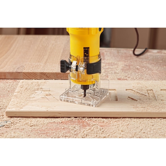 STANLEY ST55-KR compact router carving letters into wood, close-up side angle, woodworking photography.