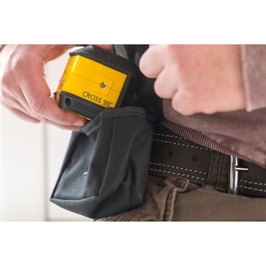 STANLEY STHT77502-1 yellow cross line laser tool held near black utility pouch on belt.