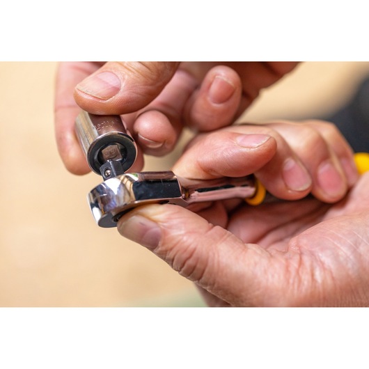 STANLEY STMT82663-0 ratchet wrench with socket held by hand, close-up photo.