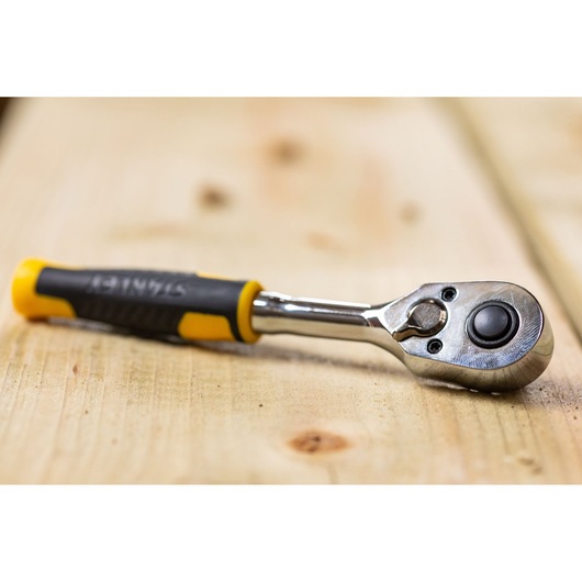 STANLEY STMT82663-0 ratchet wrench with yellow and black handle on wooden surface, product photography.