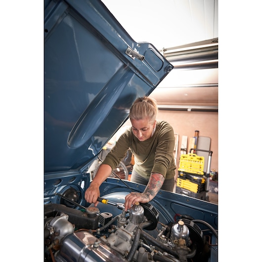 Photo of STANLEY STMT82665-0 1272-ToothRatchet used on car engine, user tightening bolt, workshop background.