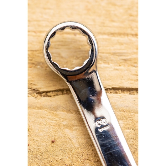 Close-up photo of STANLEY STMT82843-0 box end wrench, chrome finish, size 13, on a wooden surface.